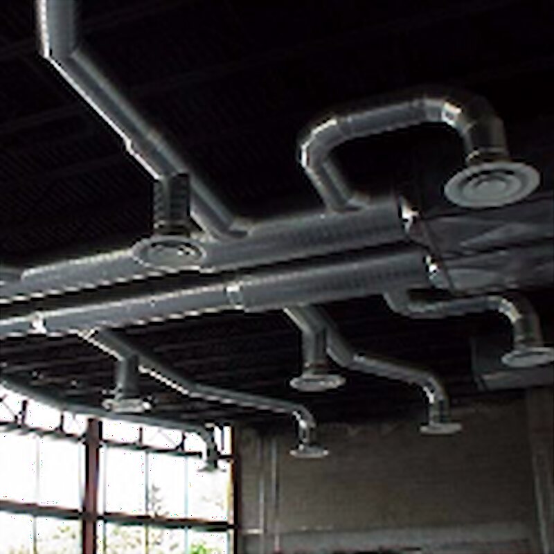 Shop-fabricated spiral ductwork routed across an industrial ceiling
