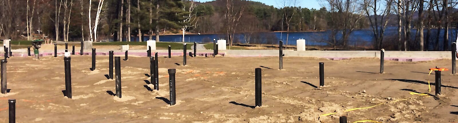 Underground plumbing rough-in stub-ups on a lakeside foundation site